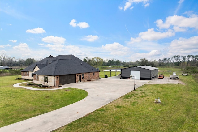 exterior space featuring a garage, a lawn, an outdoor structure, and driveway