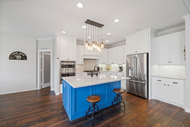 kitchen featuring light countertops, ornamental molding, appliances with stainless steel finishes, white cabinets, and dark wood-style flooring