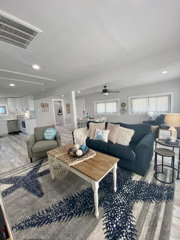 living room with visible vents, recessed lighting, attic access, and a ceiling fan