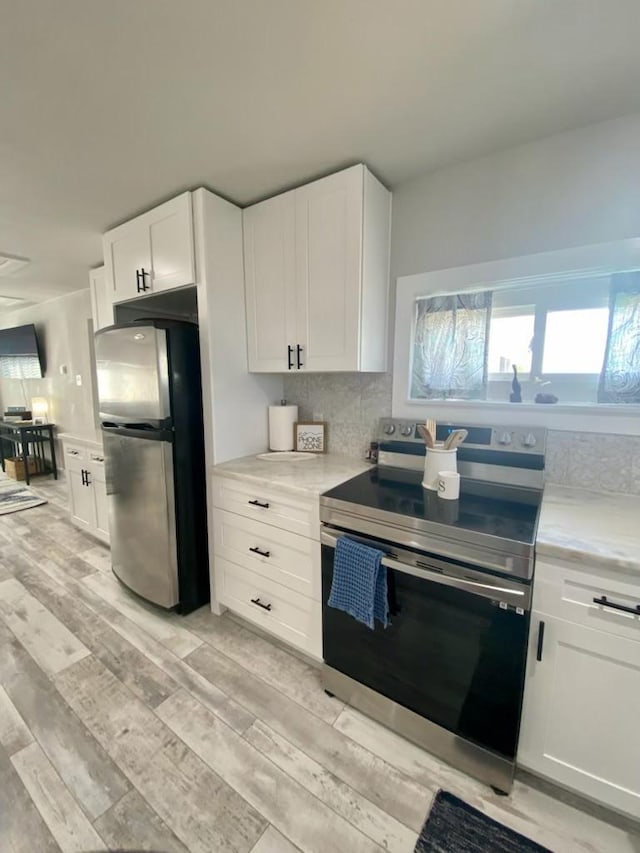 kitchen featuring light countertops, light wood-style flooring, white cabinets, and stainless steel appliances