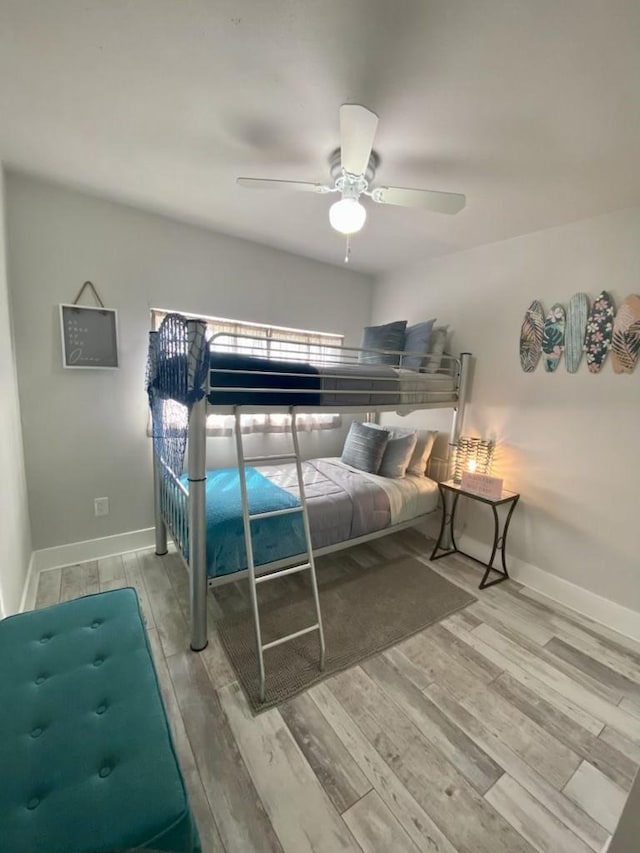 bedroom with a ceiling fan, baseboards, and wood finished floors