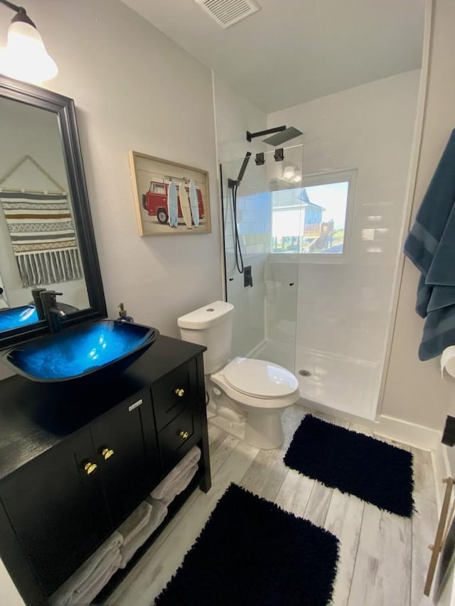 full bath with visible vents, a walk in shower, toilet, and vanity