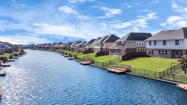 view of water feature featuring a floating dock, fence, and a residential view