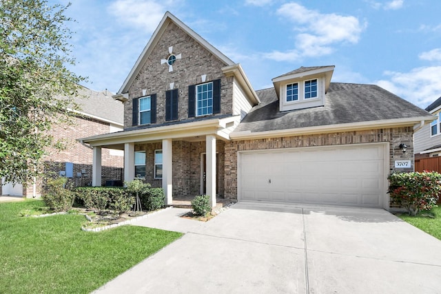 traditional home featuring driveway, a porch, a front yard, an attached garage, and brick siding