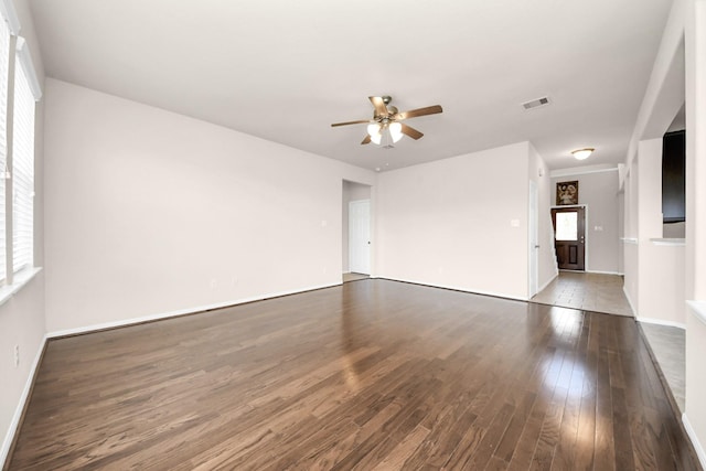 spare room featuring a wealth of natural light, visible vents, a ceiling fan, and wood finished floors