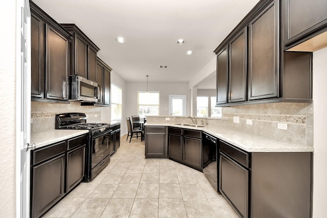 kitchen with dark brown cabinetry, decorative backsplash, light tile patterned flooring, black appliances, and a sink