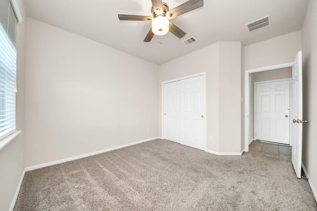 unfurnished bedroom featuring a closet, baseboards, visible vents, and carpet floors