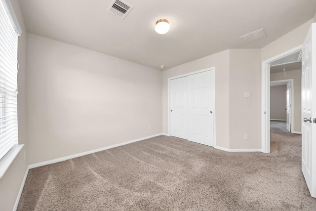 spare room with baseboards, visible vents, carpet floors, and attic access