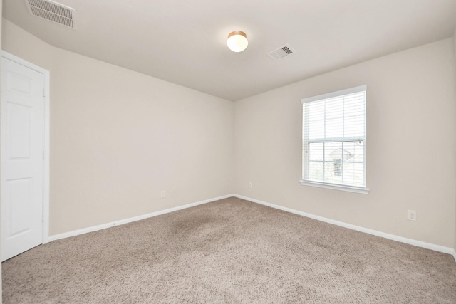 spare room featuring baseboards, visible vents, and carpet floors