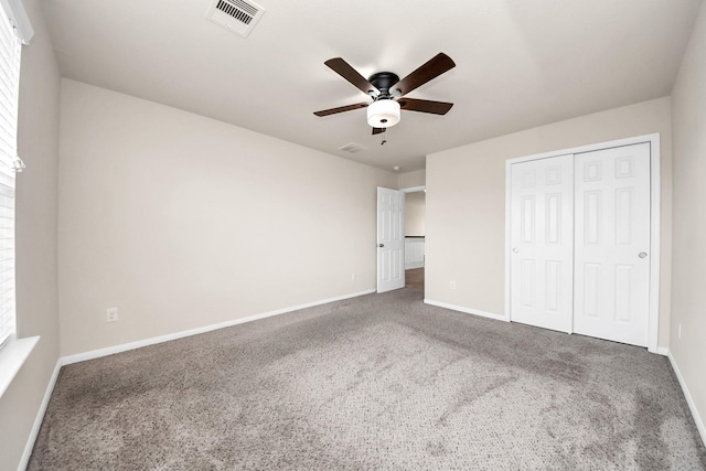 unfurnished bedroom featuring carpet flooring, baseboards, visible vents, and a closet