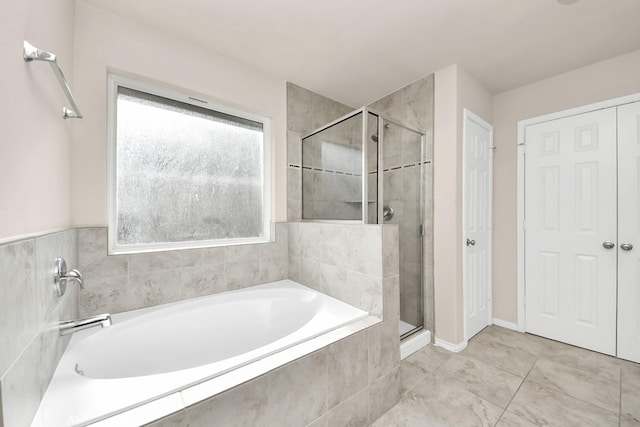 bathroom featuring a bath and a shower stall