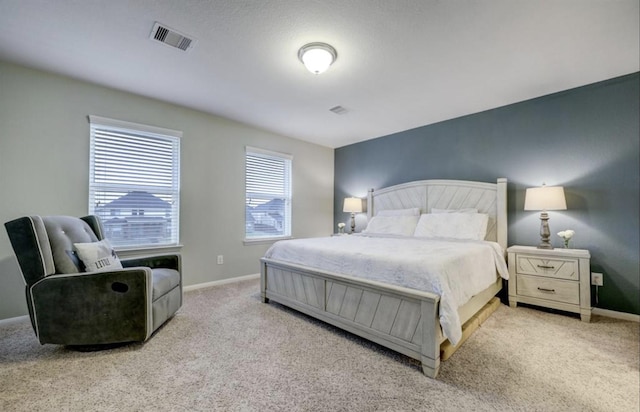 carpeted bedroom featuring baseboards and visible vents