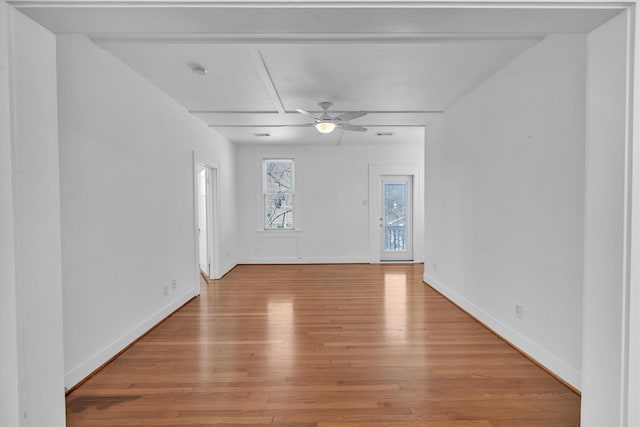 spare room featuring baseboards, light wood-type flooring, and ceiling fan