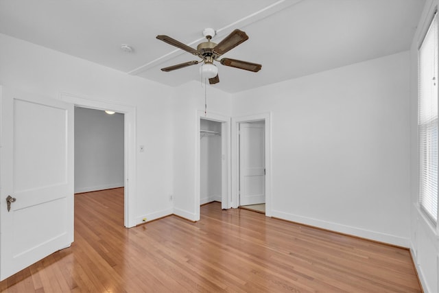 unfurnished bedroom with a closet, baseboards, light wood-style floors, and a ceiling fan