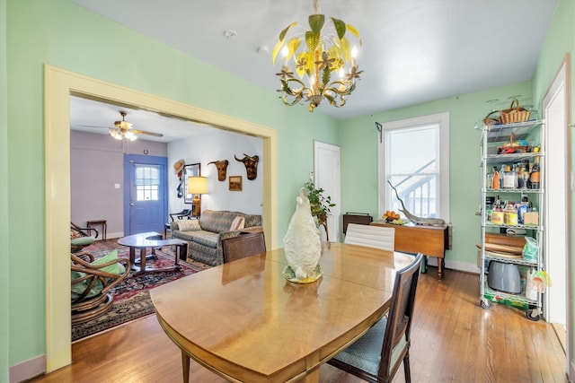 dining area with hardwood / wood-style floors, a notable chandelier, and baseboards