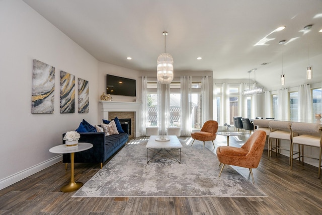 living room with a glass covered fireplace, recessed lighting, baseboards, and wood finished floors