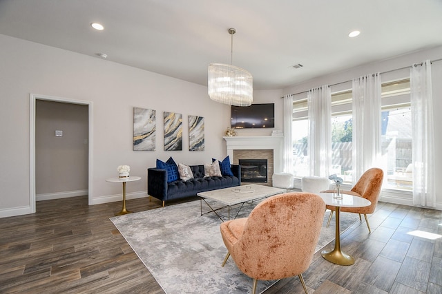 living area featuring visible vents, baseboards, a stone fireplace, recessed lighting, and dark wood-style flooring