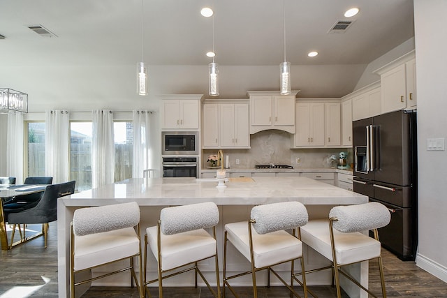 kitchen with white cabinetry, backsplash, appliances with stainless steel finishes, and a kitchen island