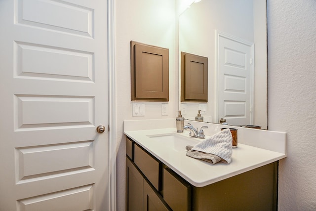 bathroom featuring vanity and a textured wall