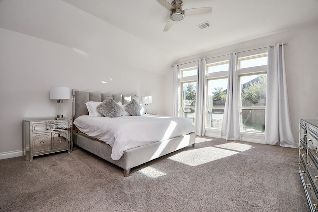 carpeted bedroom with vaulted ceiling, baseboards, visible vents, and ceiling fan