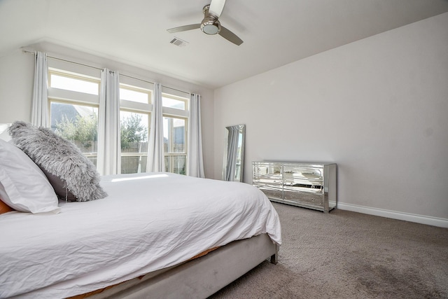 carpeted bedroom with visible vents, a ceiling fan, baseboards, and vaulted ceiling