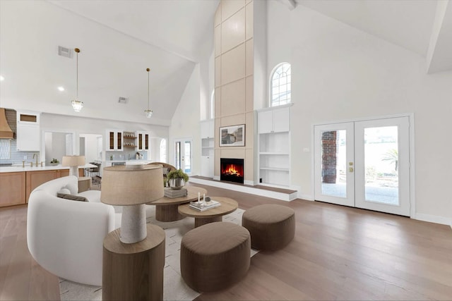 living area featuring visible vents, a healthy amount of sunlight, a fireplace, and light wood-type flooring