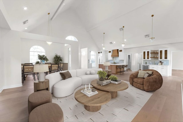 living room with visible vents, light wood-style flooring, high vaulted ceiling, and baseboards