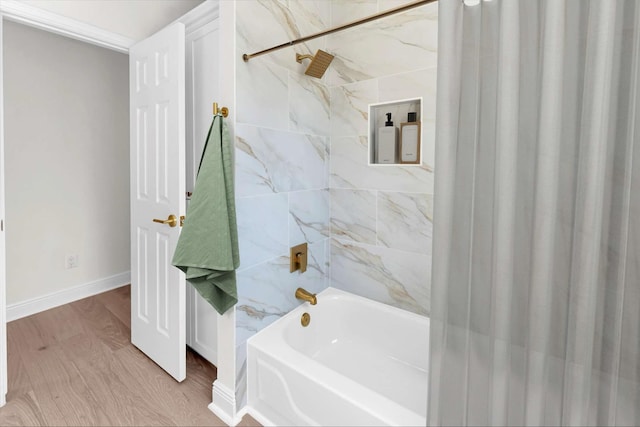 bathroom with wood finished floors, shower / bath combo, and baseboards