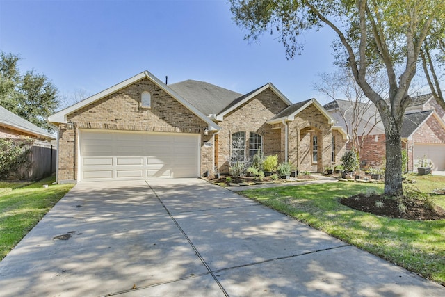 view of front of property featuring brick siding, driveway, a front yard, and a garage