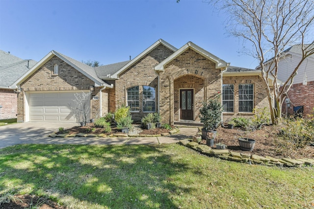 view of front of house with brick siding, a front yard, an attached garage, and driveway