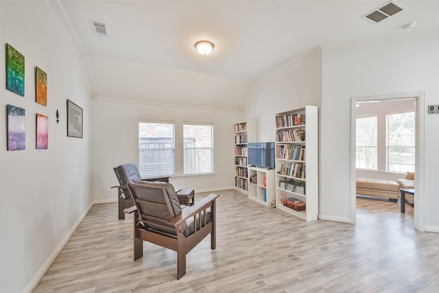 living area with a wealth of natural light, visible vents, and ornamental molding