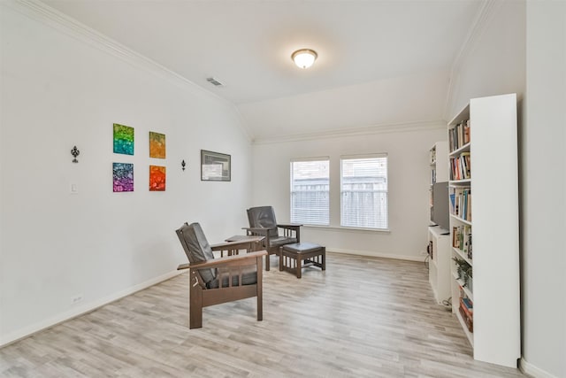 sitting room with visible vents, light wood-style flooring, crown molding, and vaulted ceiling