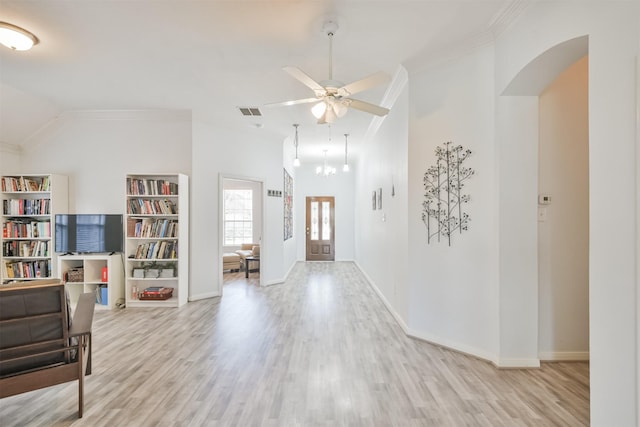 interior space featuring visible vents, ornamental molding, wood finished floors, baseboards, and ceiling fan