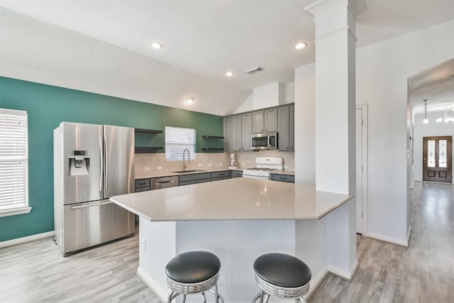 kitchen with visible vents, decorative columns, gray cabinets, stainless steel appliances, and a sink