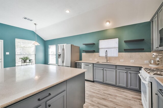 kitchen with open shelves, appliances with stainless steel finishes, gray cabinets, and a sink