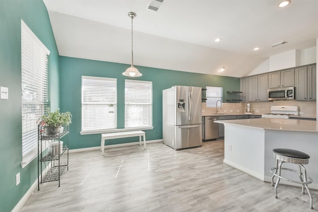 kitchen with visible vents, lofted ceiling, appliances with stainless steel finishes, and light countertops