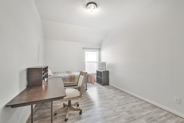 office area with baseboards, wood finished floors, and vaulted ceiling