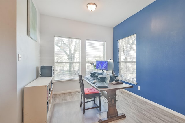 office featuring plenty of natural light, light wood-style floors, and baseboards