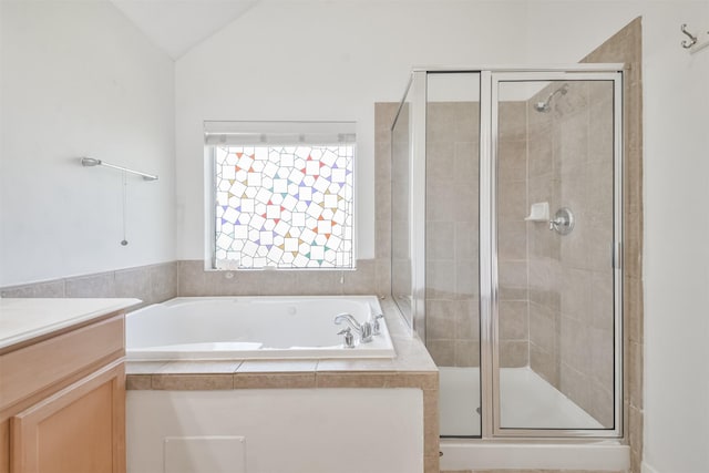 full bath with a shower stall, vanity, a garden tub, and vaulted ceiling