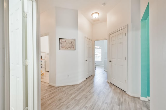 corridor with light wood finished floors and baseboards