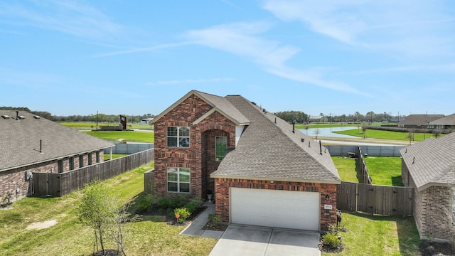 traditional home featuring driveway, roof with shingles, an attached garage, a front lawn, and brick siding