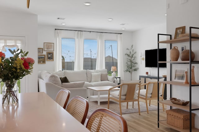 living room with light wood-type flooring, visible vents, and recessed lighting