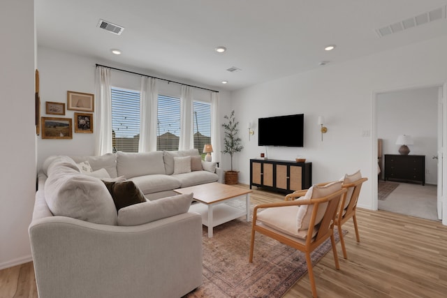 living area with recessed lighting, visible vents, and light wood finished floors