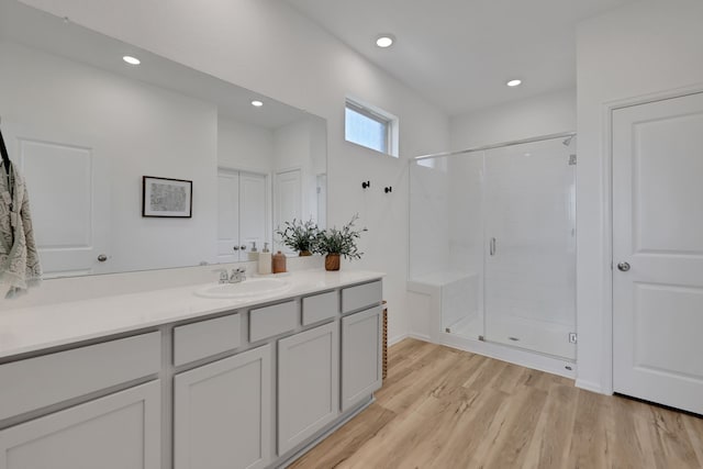 bathroom featuring recessed lighting, a shower stall, vanity, and wood finished floors