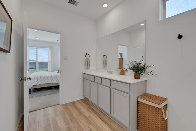 bathroom with visible vents, wood finished floors, recessed lighting, connected bathroom, and vanity