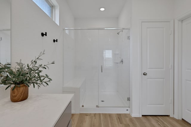 full bath with a shower stall and wood finished floors