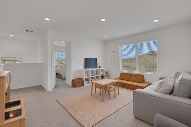 living area featuring recessed lighting, visible vents, light carpet, and a healthy amount of sunlight