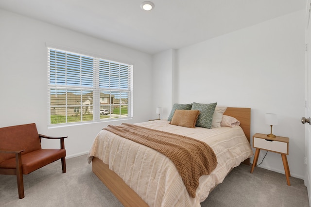 bedroom featuring light colored carpet and baseboards