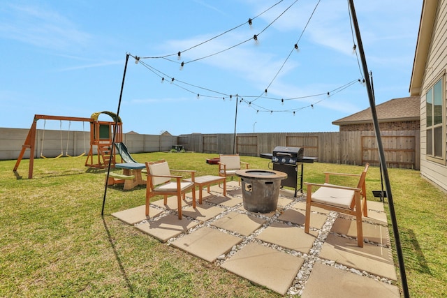 view of patio / terrace featuring a grill, an outdoor fire pit, a playground, and a fenced backyard