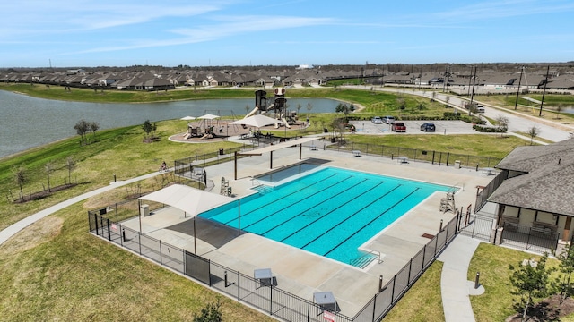 pool featuring a patio area, a residential view, fence, and a water view